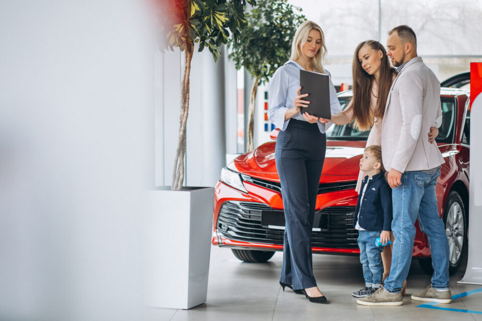 Family with son choosing a car in a car showroom